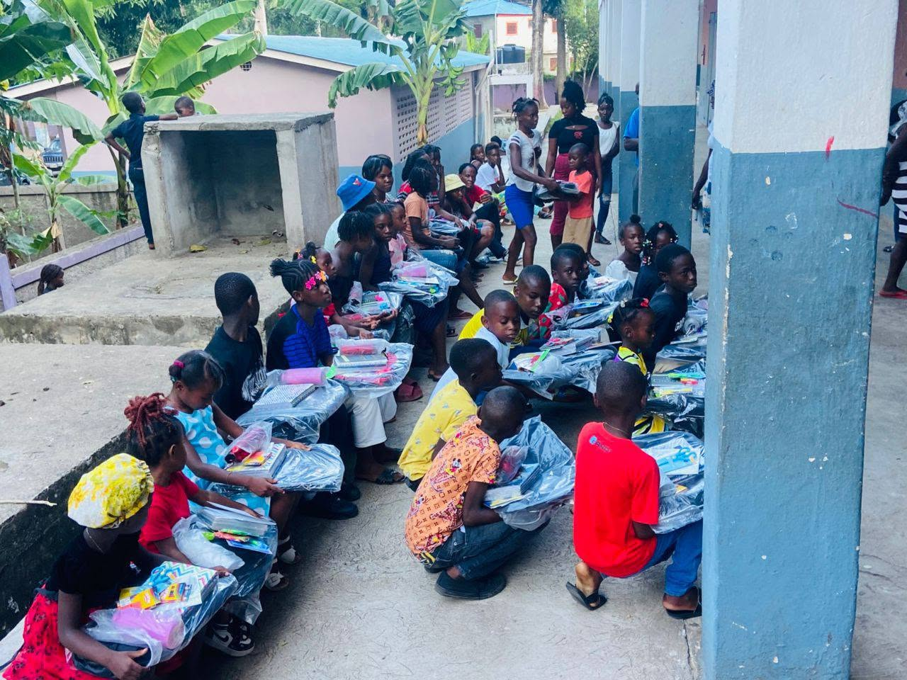 Enfants recevant des kits scolaires à la Grande-Rivière-du-Nord